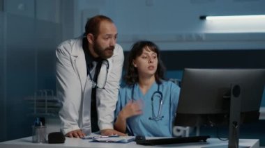 Hastalığı tedavi etmek için ilaç tedavisini tartışırken hasta uzmanlığını inceleyen tıbbi personel. Doktor ve hemşire hastane ofisinde saatlerce çalışıyorlar. İlaç servisi.