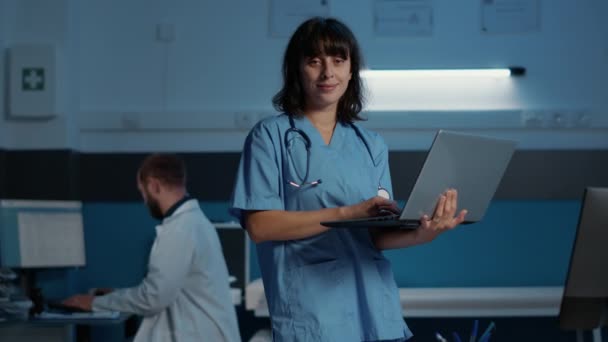 Asystentka Niebieskim Mundurze Trzymająca Laptopa Analizująca Raport Chorobie Pacjenta Pisząca — Wideo stockowe