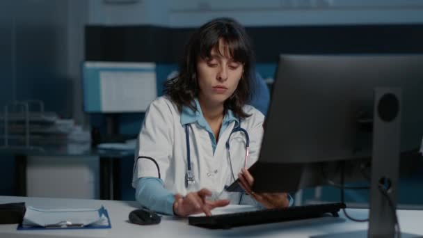 Doktor Hastane Ofisinde Geç Saatlere Kadar Çalışırken Bilgisayardaki Tıbbi Uzmanlık — Stok video