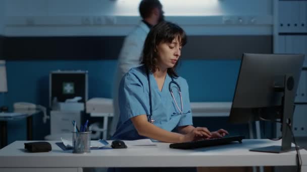Läkarassistent Som Står Vid Skrivbordet Och Analyserar Patientens Medicinska Rapport — Stockvideo