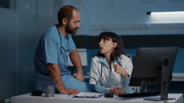Médico Praticante Mesa Com Assistente Analisando Experiência Médica Discutir Relatório — Vídeo de Stock