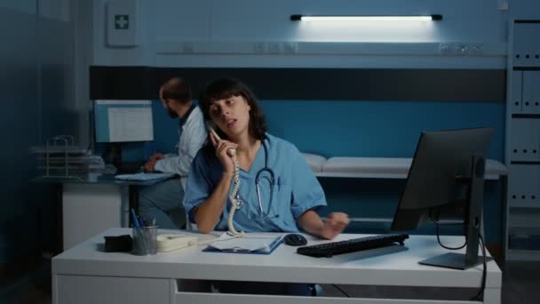 Enfermeira Caucasiana Falando Telefone Fixo Tendo Discussão Remota Com Médico — Vídeo de Stock