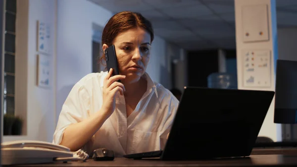 Ofis Işindeki Akıllı Telefondan Konuşan Geceleri Rapor Hazırlamak Için Dizüstü — Stok fotoğraf