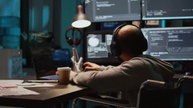 Yazılım mühendisi yeni kod programlamak için bilgisayarın terminal penceresini kullanıyor, fiziksel bozukluklarla başa çıkmak için. Tekerlekli sandalye kodlama güvenlik duvarı ya da html senaryosunda erkek ağ geliştirici. El kamerasıyla..