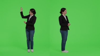 Kadın menajer tüm yeşil perde arkaplanının üzerinde reklam yapıyor. Stüdyoda reklam veya örnek gösteriyor. Yeşil ekran arkaplanında duran sunum simgesini gösteren ofis çalışanı.
