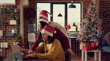 Festival alanında takım çalışması yapan, Noel Baba şapkası takan ve rapor üzerinde çalışan çok ırklı kadınlardan oluşan bir ekip. Yılbaşı tatilinde dekorasyonlarla birlikte yeni fikirlerin üzerinde kafa yoruyoruz..