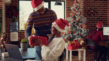 Afrika kökenli Amerikalı iş arkadaşları, kış tatilini kutlamak için hediye alışverişinde bulunuyorlar. İnsanlar Noel zamanı, mevsimlik dekorlarla mutlu hissederler..