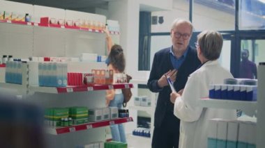 Eczacı, mide ekşimesi ve kardiyovasküler problemden muzdarip hasta adama kardiyoloji hapları veriyor. Kalp tedavisi ve ilaç arayan yaşlı bir müşteri. Üçayak atışı.