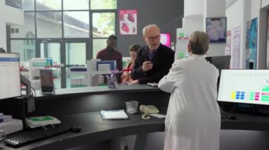 Son sınıf öğrencisi eczane tezgahına kutu kutu takviye ve hap koyar, reçeteli tedavi ya da yazarkasadan ilaç alır. Eczanedeki müşteri ilaç almak için sırada bekliyor..