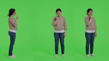 Karar vermek için beyin fırtınası yapan düşünceli bir kadın, izole edilmiş yeşil ekranın arkasında duruyor. Çözüm hakkında düşünen ve yeşil ekranda düşünceli davranan kadın modeli..