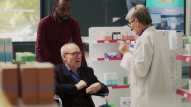 Afrikalı Amerikalı bir adam yaşlıları tekerlekli sandalyeye itiyor eczanede ilaç arıyor. Eczanede kronik özürlü birine eczacı hakkında soru sormak. El kamerasıyla..