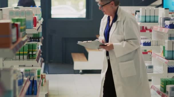 薬局の棚から薬やビタミンを購入しようとして 治療について薬剤師に尋ねる処方紙を持つ若い大人 薬局でサプリメントのチェックボックス — ストック動画