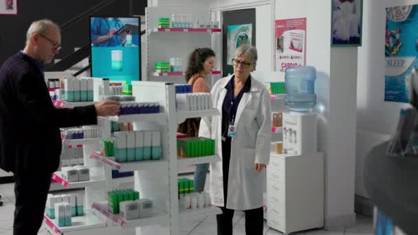 Усміхнений Фахівець Охорони Здоров Який Працює Аптеці Коробками Ліків Полицях — стокове відео