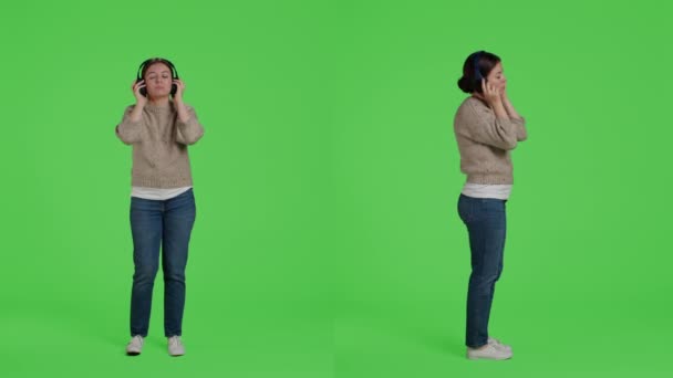Ευτυχισμένη Γυναίκα Ακούγοντας Μουσική Ακουστικά Διασκεδάζοντας Στο Στούντιο Φόντο Πράσινης — Αρχείο Βίντεο