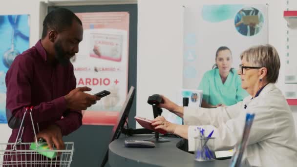 Afrikanisch Amerikanischer Kunde Nutzt Mobiles Nfc Payment Auf Pos Vitamine — Stockvideo