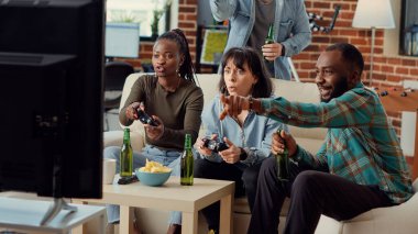 Çok ırklı arkadaş grupları bilgisayar oyunları yarışmalarıyla eğleniyor, oyun konsolu ve televizyonla online mücadele ediyorlar. Neşeli insanlar takılarak oyun oynamaktan zevk alıyorlar. El kamerasıyla..