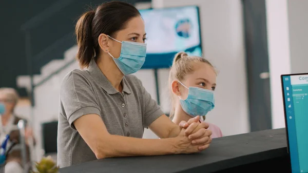 Yüzü Maskeli Anne Çocuk Hastane Resepsiyonunda Resepsiyonistle Konuşuyor Insanlar Pratisyen — Stok fotoğraf