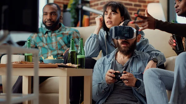 ゲーム機でオンラインビデオゲームを楽しんでいる人々のグループは 仮想現実ヘッドセットで挑戦しています テレビで競争を再生するためにVrガラスを使用しています 手持ち撮影 — ストック写真