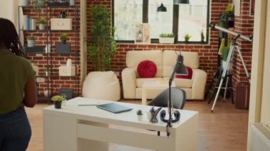 Erkek çalışan masa başında dizüstü bilgisayarla serbest çalışmak için oturuyor, veri ve bilgilerle şirket raporu oluşturmak için çevrimiçi ağı kullanıyor. Şirket çalışanı oturma odasında uzaktan kumanda yapıyor..