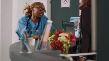 Hastane resepsiyonunda hastaların sağlık kontrollerini tartışan tıbbi personel ekibi. Hemşire ve resepsiyonist resepsiyonda bekliyor..