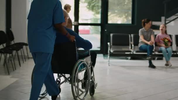 Krankenschwester Hilft Mann Rollstuhl Familie Klinik Lobby Treffen Alter Patient — Stockvideo