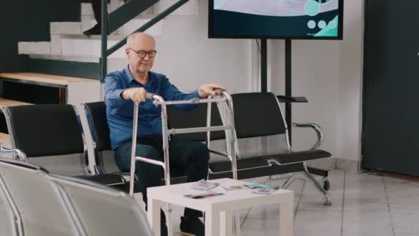 老年病人坐在保健中心的候诊室里 谈论药物和医疗预约 老男人 有走路的姿势 在大堂和生病的老妇人交谈 — 图库视频影像