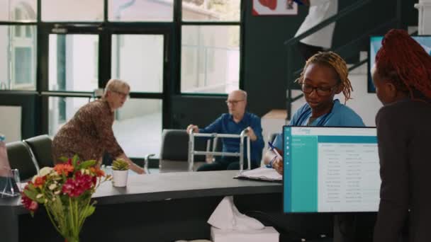 Африканська Американська Медсестра Секретарка Розмовляє Рецептом Дивлячись Файли Реєстрації Старша — стокове відео
