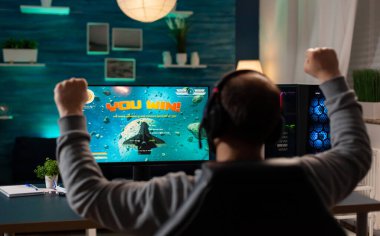 Heyecanlı oyuncu profesyonel kulaklıkla yarışma turnuvasındaki uzay nişancısı video oyununu kazandı. Çevrimiçi yayın yapan siber oyun teknolojisi kablosuz ağ kullanıyor