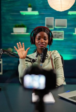 Afro içerik yaratıcısı, kulaklık takan dinleyiciler için harika olduğunu söylüyor. Canlı yayın yapan internet yayın sunucusu dijital sosyal medyayı kaydediyor.