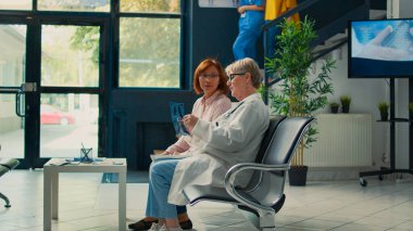 Yaşlı doktor, tesis lobisindeki bekleme odasında oturan Asyalı kadına kemik röntgeni teşhisi koyuyor. Hastalığa karşı tedavi ve sigorta desteği bulmak için radyografi tarama sonuçlarına bakıyorum..