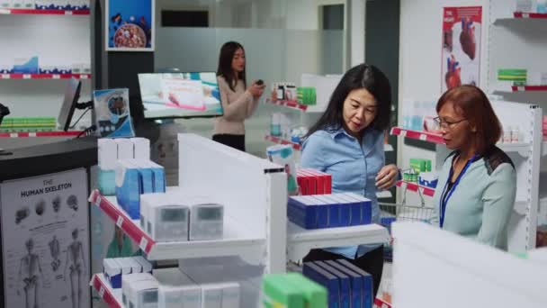 Farmacéutica Ayudando Cliente Asiático Encontrar Medicamentos Dando Pastillas Caja Mujer — Vídeo de stock
