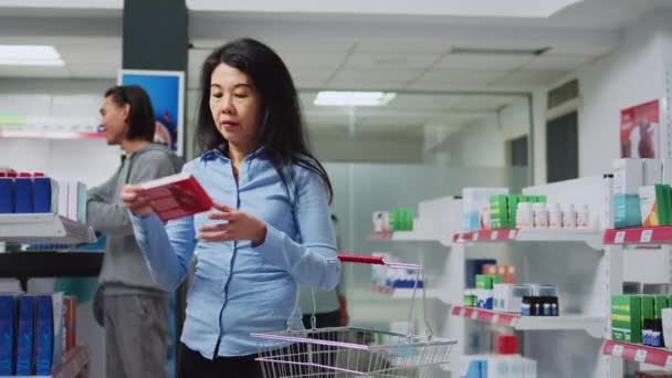 Femme Cliente Analysant Des Boîtes Médecine Cardiaque Dans Magasin Pharmacie — Video
