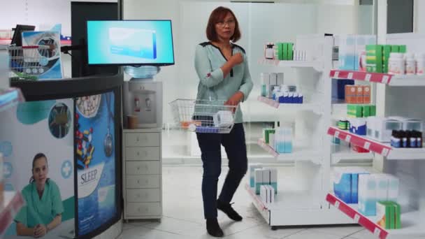 Γυναίκα Πελάτης Βάζοντας Κουτιά Των Φαρμάκων Στο Καλάθι Κοιτάζοντας Πακέτο — Αρχείο Βίντεο