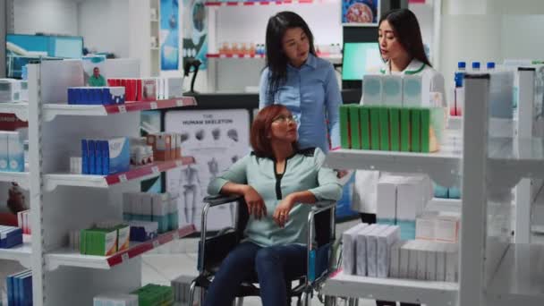 Azjaci Rozmawiają Pracownikami Leczeniu Witaminach Kliencie Przewlekłą Niepełnosprawnością Aptece Opiekun — Wideo stockowe