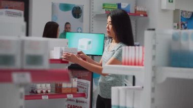 Tedavi satın almak için ilaç ürünlerine bakan yaşlı müşteriler, raflardaki ilaç paketlerini analiz ediyorlar. İlaç ve malzeme arayan bir kadın, eczane. El kamerasıyla..