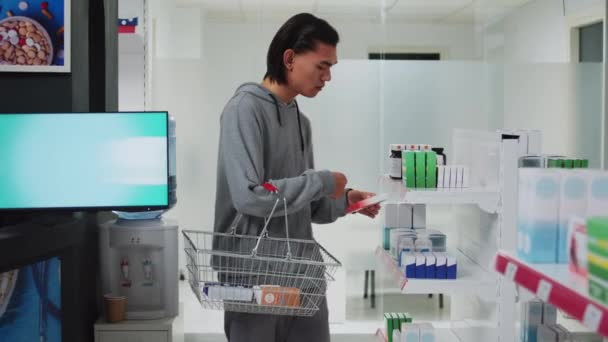 Cliente Masculino Analizando Cajas Suplementos Estantes Farmacia Examinando Vitaminas Para — Vídeos de Stock