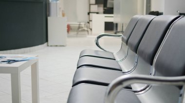 Tesis lobisinde koltukları olan klinik bekleme alanı, resepsiyon resepsiyonunda hasta kaydını çözmek için tıbbi randevuya katılmadan önce kullanılır. Sağlık merkezinde boş resepsiyon masası.