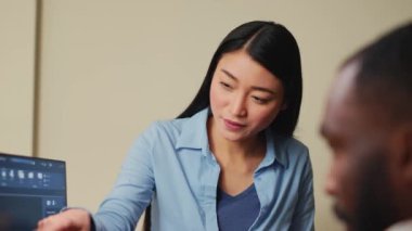 Asyalı endüstriyel mühendis 3D editörün kaba bir prototip geliştirmesine yardım ediyor, yaratıcı ajans ofisinde grafik yazılımla takım çalışması yapıyor. Mühendislik eğitimi alan iş arkadaşları.