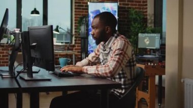 Afro-Amerikan bir adam 3 boyutlu mühendislik veya cgi üzerinde çalışıyor. Adi yazılım ve profesyonel sanat arayüzü kullanıyor. İçerik oluşturucu bilgi grafikleri planlama, hazırlama, üretim becerileri geliştirme.