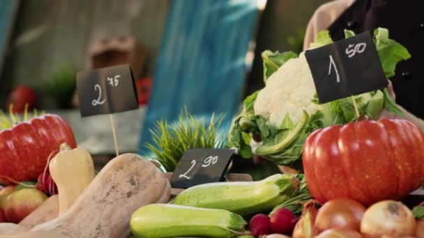 顧客のためのカリフラワー製品を保持する女性の八百屋は カードや葉で有機バイオ製品を販売しています 新鮮な自然野菜を示すエプロン付きの農民市場の売り手 閉じろ — ストック動画