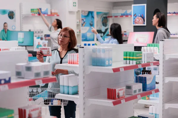 Азиатский Клиент Анализирует Коробку Кардиологических Препаратов Проверяет Медицинскую Брошюру Аптеке — стоковое фото