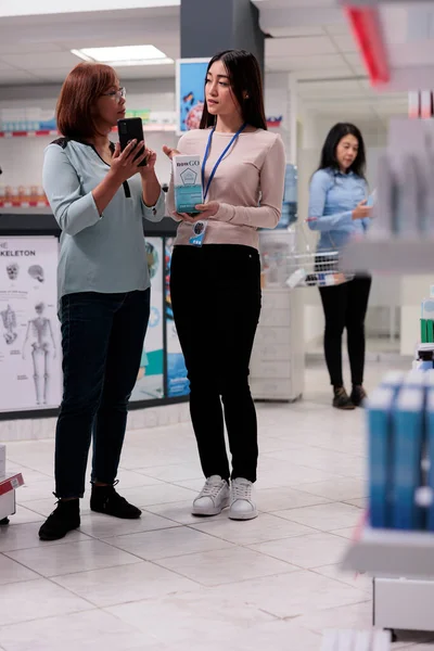Akıllı Telefondan Uzmanlara Haplar Gösteren Bir Müşteri Eczaneden Ilaç Almak — Stok fotoğraf