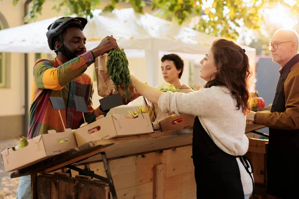 若い地元のベンダーは 果物や野菜の食品の配達を支援し 配達人に天然バイオ製品の注文を与えます 農家の市場で有機エコ製品を作る女性農家 — ストック写真
