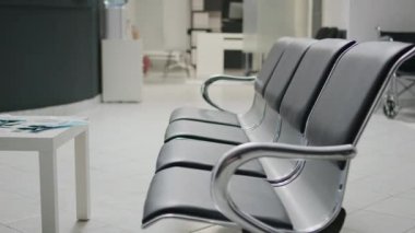 Tesis lobisinde koltukları olan klinik bekleme alanı, resepsiyon resepsiyonunda hasta kaydını çözmek için tıbbi randevuya katılmadan önce kullanılır. Sağlık merkezinde boş resepsiyon masası.