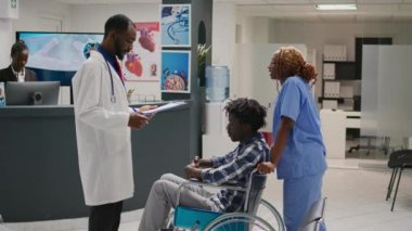 Afrikalı Amerikalı bir adama fiziksel engelli olarak yardım etmek, erkek tekerlekli sandalye kullanıcısını doktorla sağlık kontrolüne hazırlamak. Kronik Engelli Sağlık Merkezi ile uğraşan kişi.