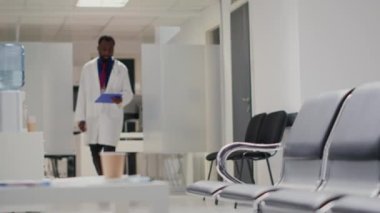 Fiziksel engelli tekerlekli sandalye kullanıcısı, hsopital bekleme odasında toplantı. Klinikte kronik bozukluk olan bir adama yardım eden hemşire, muayene randevusu. El kamerasıyla..