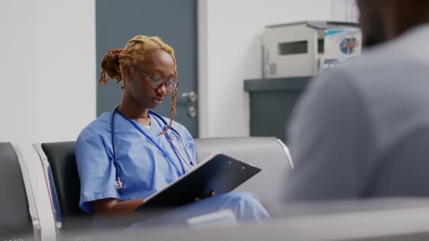 Tıbbi Asistan Bekleme Lobisindeki Check Raporlarını Analiz Ediyor Hastane Resepsiyonunda — Stok video