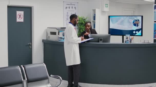 Tıbbi Randevu Planlamak Için Resepsiyonistle Çalışan Pratisyen Hekim Hastane Çalışanı — Stok video