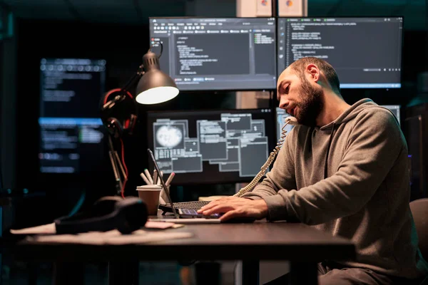 소프트웨어 엔지니어는 전화로 시간에 이야기하고 사무실 전화에 응답하여 터미널 창에서 — 스톡 사진