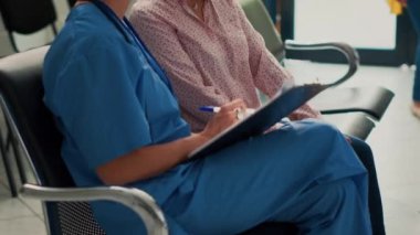 Çeşitli insanlar hastalık hakkında konuşuyor ve check-up yapıyor, hemşire tıbbi raporlar hakkında notlar alıyor destek ve tedavi için. Tesisteki yaşlı hastalara danışmanlık yapan uzman..